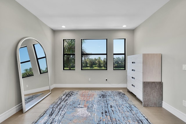 spare room with baseboards, recessed lighting, and light wood-type flooring