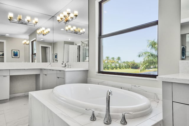 bathroom featuring a chandelier, a garden tub, marble finish flooring, and vanity
