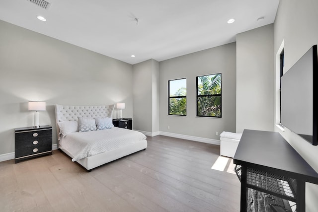 bedroom with baseboards, wood finished floors, and recessed lighting