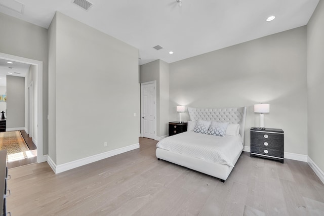 bedroom featuring wood finished floors, baseboards, and recessed lighting