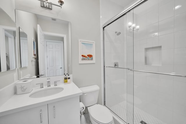 full bathroom with a stall shower, toilet, and vanity