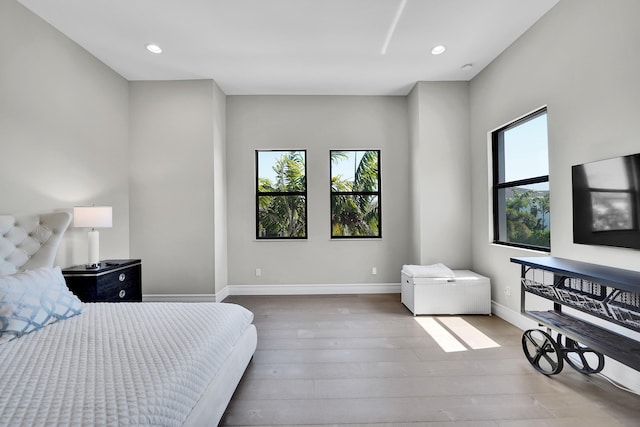 bedroom with wood finished floors, recessed lighting, and baseboards