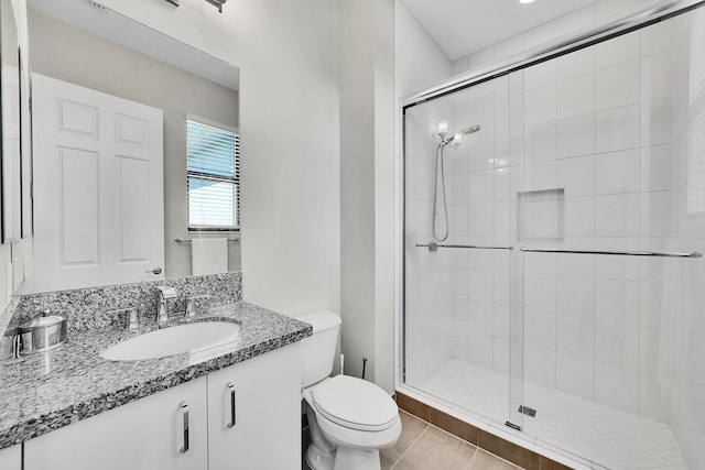 bathroom with toilet, a stall shower, tile patterned floors, and vanity