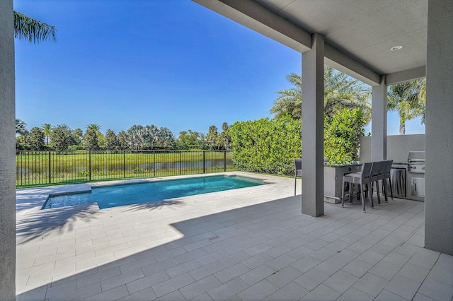 view of swimming pool featuring a patio area, a grill, and a water view