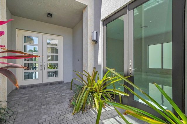 entrance to property featuring french doors and stucco siding