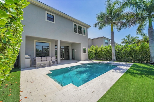 view of swimming pool featuring a patio and a yard