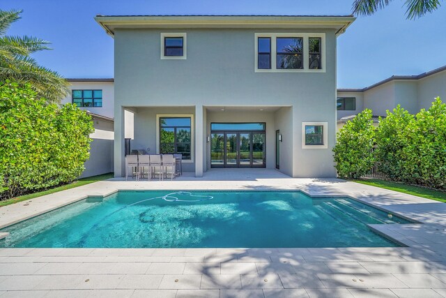 back of house featuring stucco siding, a patio area, and an outdoor pool