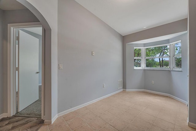 3810 N Jog Rd Unit 204, West Palm Beach, FL 33411 - spare room featuring baseboards, arched walkways, and light tile patterned flooring