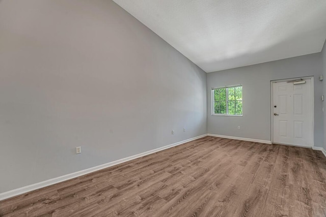 3810 N Jog Rd Unit 204, West Palm Beach, FL 33411 - empty room with wood finished floors, baseboards, and lofted ceiling