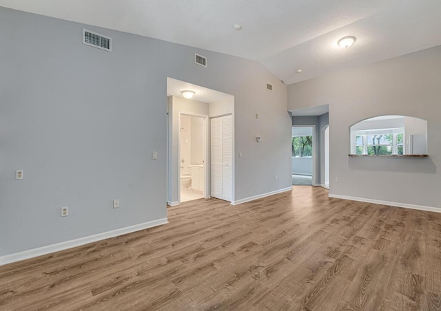 3810 N Jog Rd Unit 204, West Palm Beach, FL 33411 - unfurnished living room with lofted ceiling, light wood-style floors, baseboards, and arched walkways