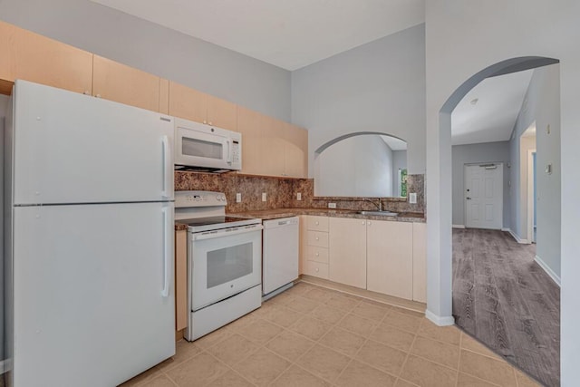 3810 N Jog Rd Unit 204, West Palm Beach, FL 33411 - kitchen with white appliances, a sink, backsplash, arched walkways, and light brown cabinets