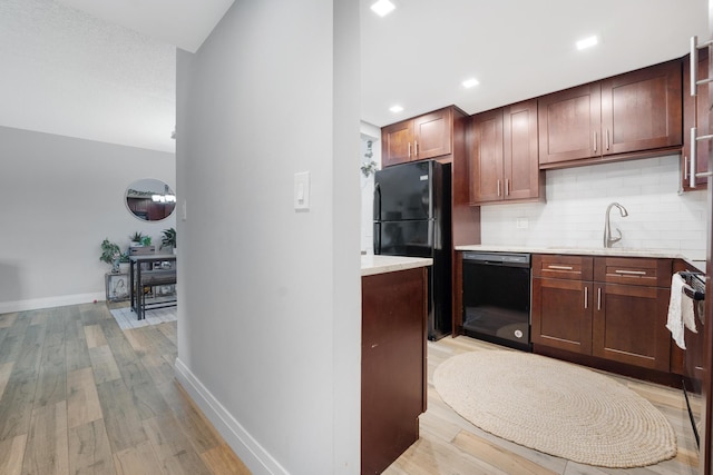 495 SE 8th St Unit 147, Deerfield Beach, FL 33441 - kitchen featuring black appliances, light countertops, tasteful backsplash, light wood-style floors, and baseboards