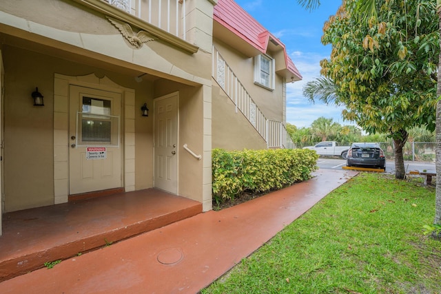 495 SE 8th St Unit 147, Deerfield Beach, FL 33441 - doorway to property featuring stucco siding and a lawn