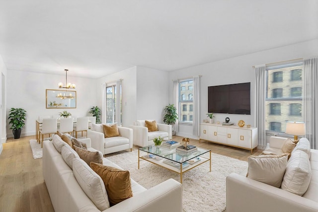 1111 S Ocean Blvd Unit 313, Boca Raton, FL 33432 - living room with a chandelier, healthy amount of natural light, light wood-style floors, and baseboards