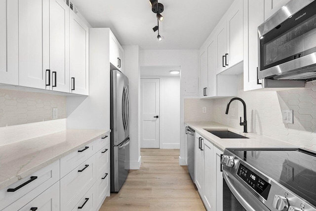 1111 S Ocean Blvd Unit 313, Boca Raton, FL 33432 - kitchen featuring stainless steel appliances, a sink, white cabinetry, and light stone counters