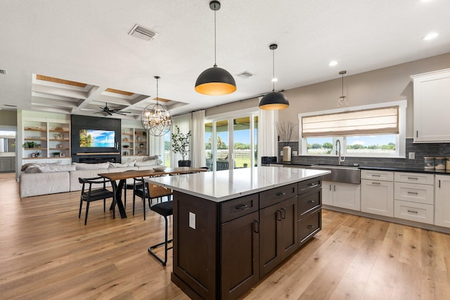 18102 Bridle Way, Port Saint Lucie, FL 34987 - kitchen with a sink, recessed lighting, light wood-style flooring, white cabinetry, and backsplash