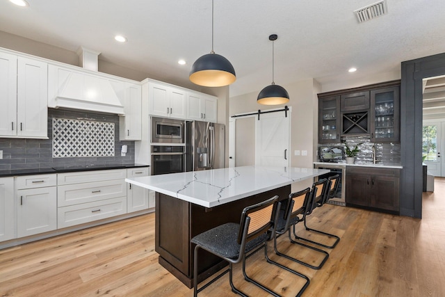 18102 Bridle Way, Port Saint Lucie, FL 34987 - kitchen featuring stainless steel appliances, a barn door, tasteful backsplash, beverage cooler, and recessed lighting