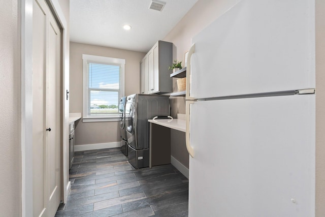 18102 Bridle Way, Port Saint Lucie, FL 34987 - washroom with cabinet space, dark wood-type flooring, washing machine and dryer, baseboards, and a desk