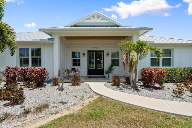 18102 Bridle Way, Port Saint Lucie, FL 34987 - view of exterior entry with french doors, a standing seam roof, metal roof, and board and batten siding