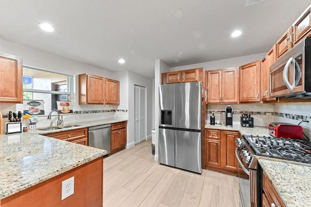 1184 Landings Run, Greenacres, FL 33413 - kitchen with appliances with stainless steel finishes, a sink, decorative backsplash, light stone counters, and recessed lighting
