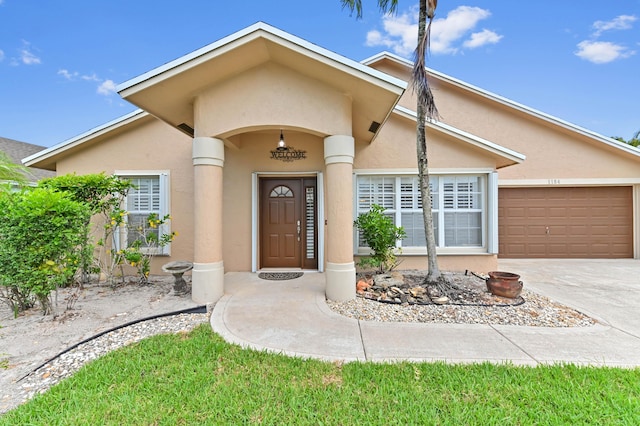 1184 Landings Run, Greenacres, FL 33413 - property entrance featuring stucco siding, driveway, and an attached garage