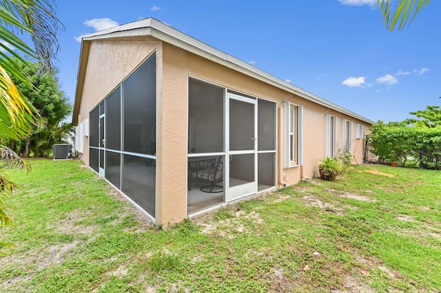 1184 Landings Run, Greenacres, FL 33413 - rear view of house featuring central air condition unit, stucco siding, a lawn, and a sunroom