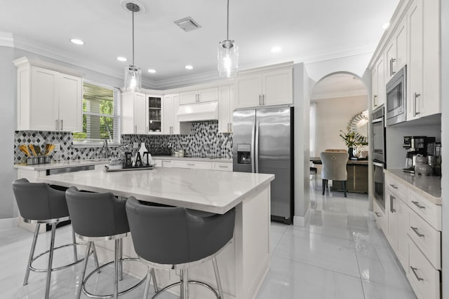 2371 Simonson Dr, Wellington, FL 33414 - kitchen with stainless steel appliances, premium range hood, a kitchen breakfast bar, white cabinetry, and backsplash