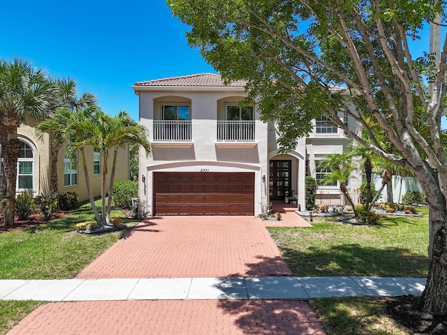 2371 Simonson Dr, Wellington, FL 33414 - mediterranean / spanish house with a garage, a balcony, stucco siding, decorative driveway, and a front lawn