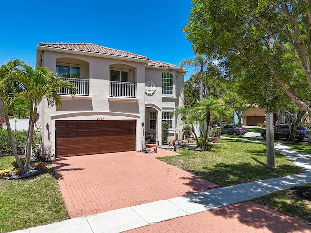 2371 Simonson Dr, Wellington, FL 33414 - mediterranean / spanish-style house featuring a balcony, a tiled roof, stucco siding, decorative driveway, and an attached garage
