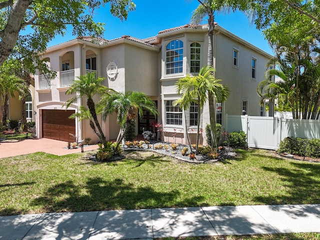 2371 Simonson Dr, Wellington, FL 33414 - mediterranean / spanish home featuring stucco siding, an attached garage, driveway, a tiled roof, and a balcony