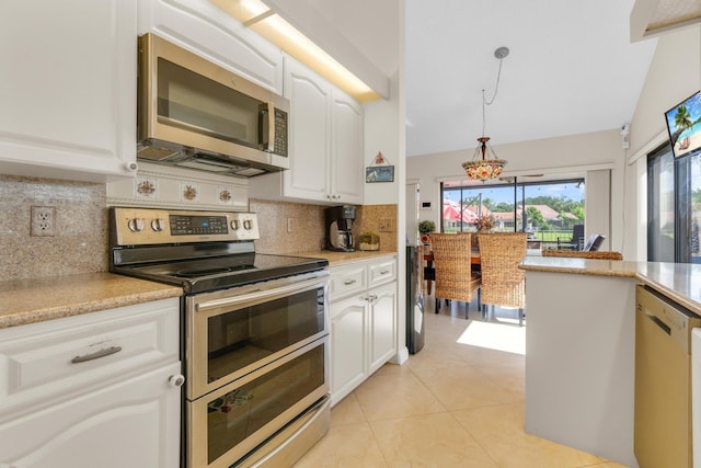 2855 Eagle Ln, West Palm Beach, FL 33409 - kitchen with appliances with stainless steel finishes, tasteful backsplash, light countertops, white cabinets, and hanging light fixtures