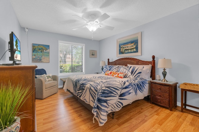 2855 Eagle Ln, West Palm Beach, FL 33409 - bedroom featuring light wood-style flooring, a textured ceiling, a ceiling fan, and baseboards