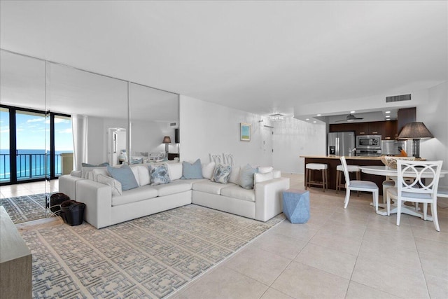 2800 N Ocean Dr Unit B-24D, Singer Island, FL 33404 - living room with floor to ceiling windows, light tile patterned flooring, and a water view