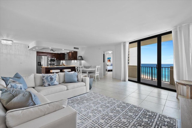 2800 N Ocean Dr Unit B-24D, Singer Island, FL 33404 - living room with light tile patterned floors, a wall of windows, and a water view