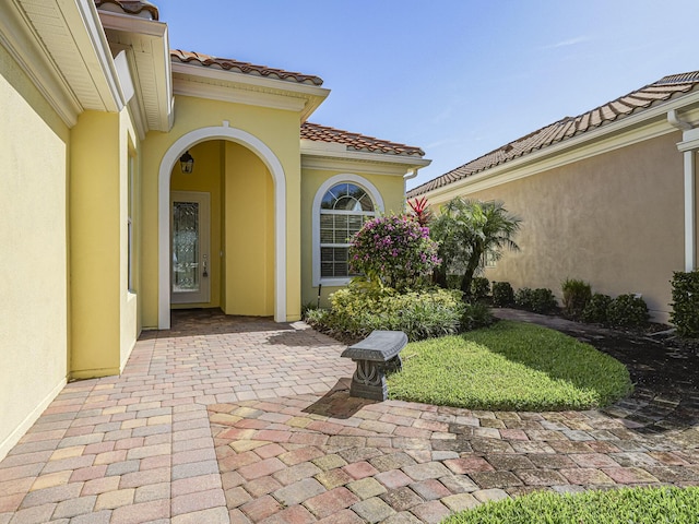 5151 Formosa Cir, Vero Beach, FL 32967 - view of exterior entry with stucco siding, a tiled roof, and a patio area