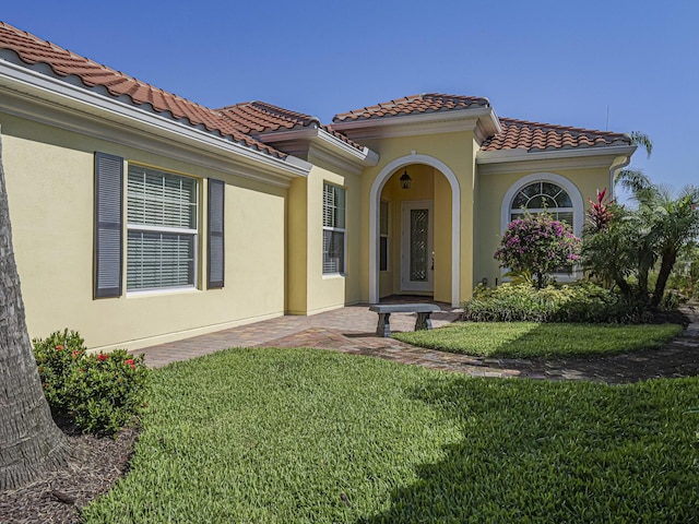 5151 Formosa Cir, Vero Beach, FL 32967 - view of front of home with a front yard, a tiled roof, and stucco siding