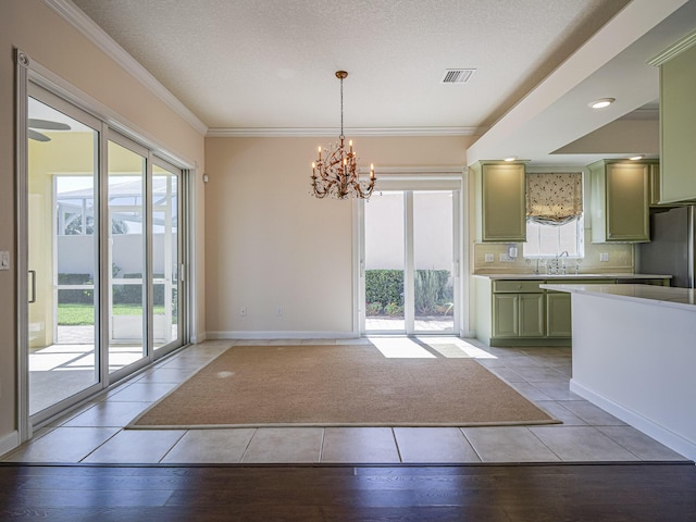 5151 Formosa Cir, Vero Beach, FL 32967 - kitchen featuring green cabinetry, a chandelier, light countertops, light wood-style flooring, and ornamental molding