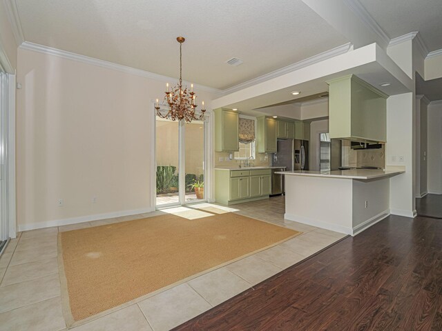 5151 Formosa Cir, Vero Beach, FL 32967 - unfurnished living room featuring ornamental molding, a sink, a chandelier, light wood-style flooring, and baseboards