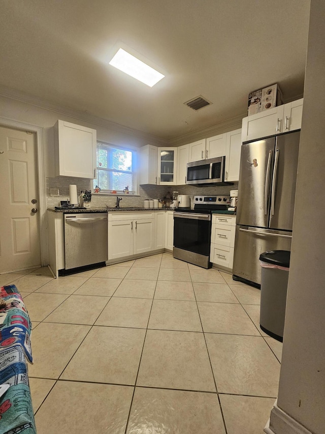 2018 S 10th St Unit C, Fort Pierce, FL 34950 - kitchen featuring stainless steel appliances, decorative backsplash, white cabinets, and light tile patterned floors