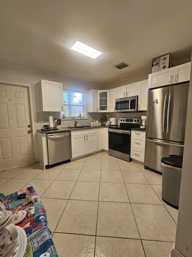 2018 S 10th St Unit C, Fort Pierce, FL 34950 - kitchen with stainless steel appliances, dark countertops, light tile patterned floors, and ornamental molding