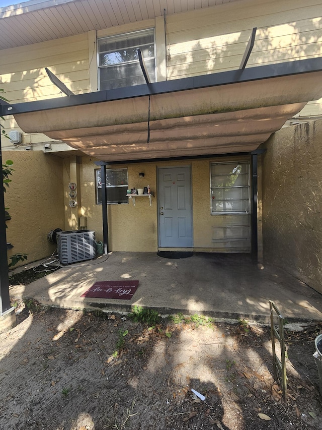 2018 S 10th St Unit C, Fort Pierce, FL 34950 - doorway to property featuring cooling unit and stucco siding