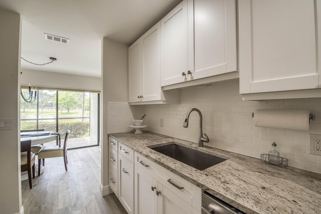 6 E Lexington Ln Unit C, Palm Beach Gardens, FL 33418 - kitchen with a sink, decorative backsplash, white cabinetry, and light stone counters