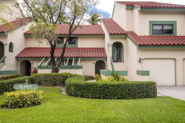 6 E Lexington Ln Unit C, Palm Beach Gardens, FL 33418 - mediterranean / spanish-style home with a front lawn, an attached garage, a tiled roof, stucco siding, and concrete driveway