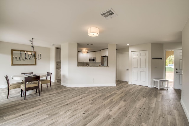 6 E Lexington Ln Unit C, Palm Beach Gardens, FL 33418 - living room with a chandelier, light wood-style flooring, and baseboards
