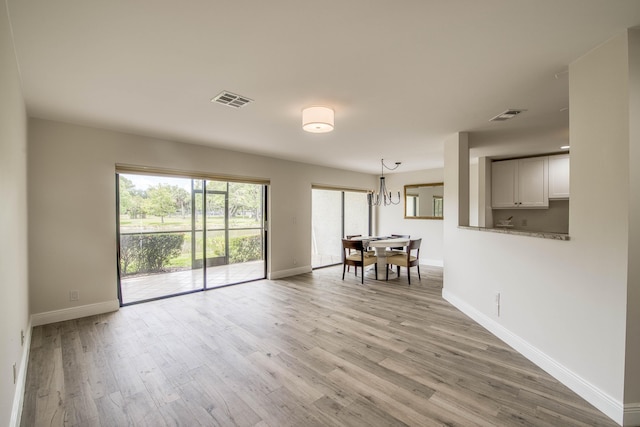 6 E Lexington Ln Unit C, Palm Beach Gardens, FL 33418 - empty room featuring baseboards, wood finished floors, and a chandelier