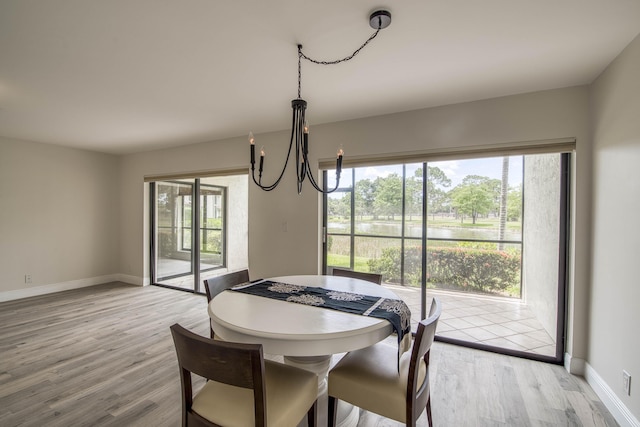 6 E Lexington Ln Unit C, Palm Beach Gardens, FL 33418 - dining room featuring a chandelier, light wood finished floors, and baseboards
