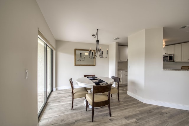 6 E Lexington Ln Unit C, Palm Beach Gardens, FL 33418 - dining room with a chandelier, light wood finished floors, and baseboards