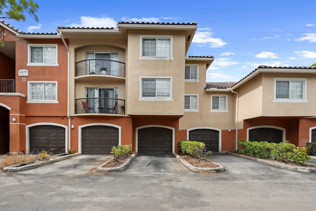 4179 N Haverhill Rd Unit 609, West Palm Beach, FL 33417 - view of front of home featuring stucco siding, an attached garage, a tiled roof, and driveway