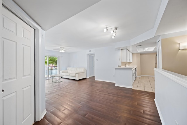 4179 N Haverhill Rd Unit 609, West Palm Beach, FL 33417 - unfurnished living room featuring a ceiling fan, wood finished floors, a sink, and baseboards