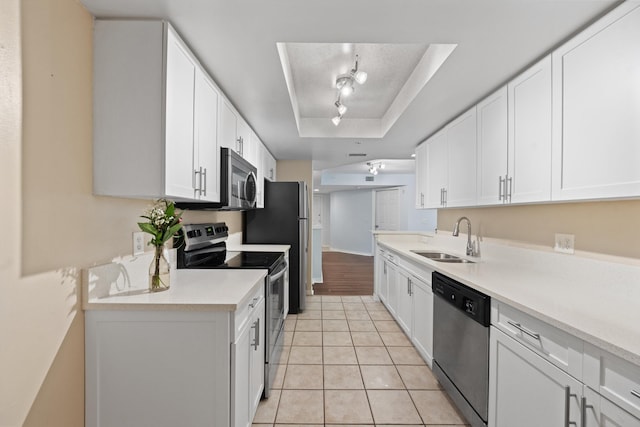 4179 N Haverhill Rd Unit 609, West Palm Beach, FL 33417 - kitchen with stainless steel appliances, a sink, a tray ceiling, track lighting, and light countertops